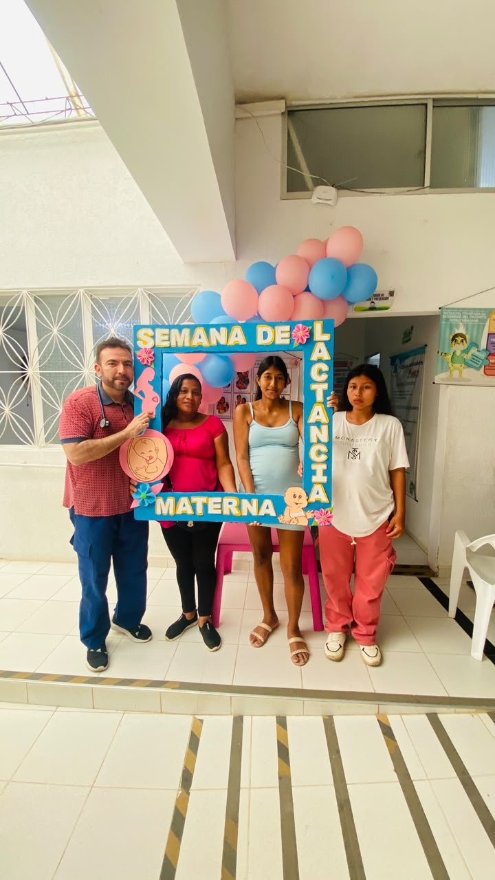 Médico y gestantes con el marco de la Semana de la lactancia materna